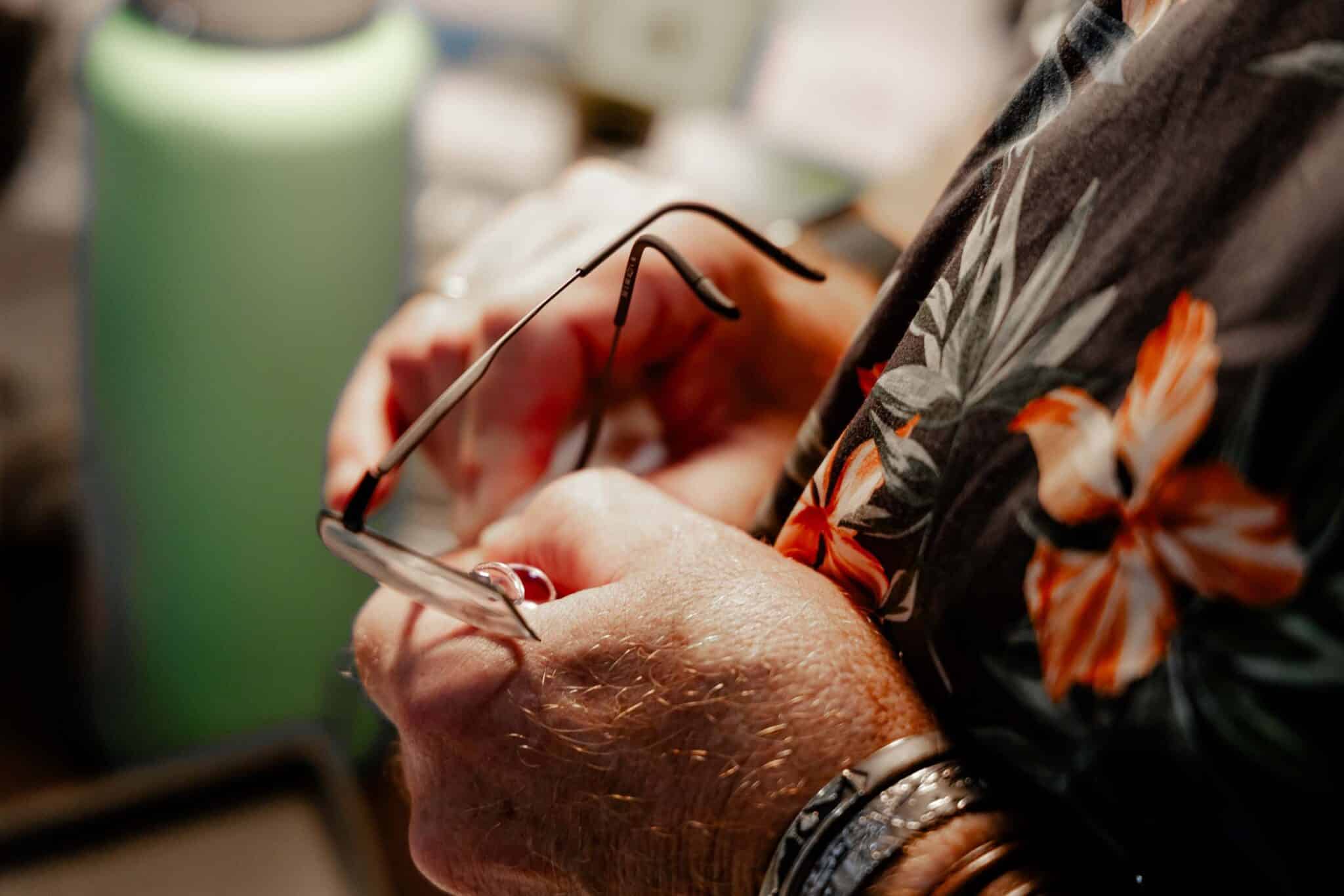 Close-up of hands adjusting a pair of glasses