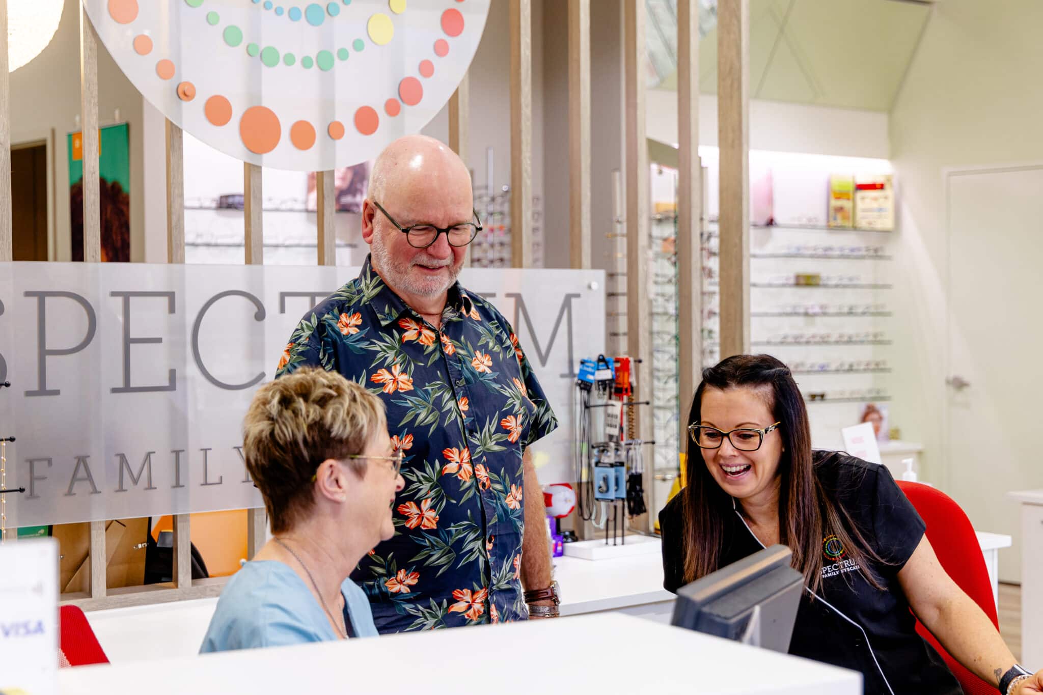 The Spectrum Family Eyecare team helping a patient at the reception counter